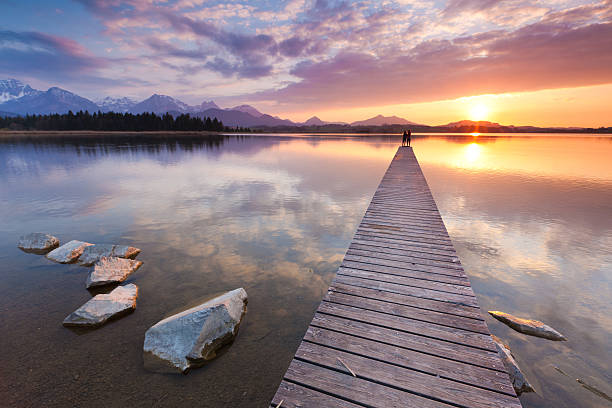 istock tranquil sunset at lake hopfensee, bavaria with jetty, germany 155377945