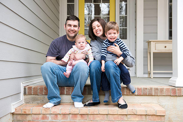 Candid portrait of family sitting on front porch stairs stock photo