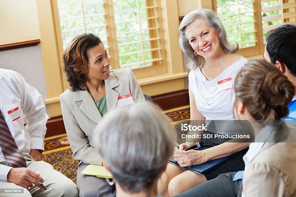 Happy senior adult woman talking in a group setting Happy senior adult woman talking about herself in a group setting.  A Helping Hand Stock Photo