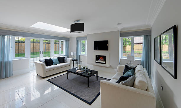 gorgeous lounge with fireplace a gorgeous lounge in an expensive new home with two cream coloured settees on either side of a coffee table with a lit gas fire in the background. Subtely decorated with light blue drapes and matching cushions. The copyright for the book design belongs to the photographer. light blue silk stock pictures, royalty-free photos & images