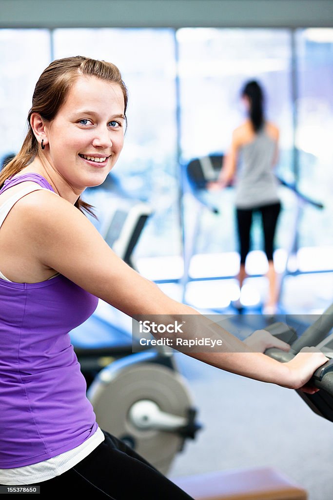 Heureuse jeune femme Offre avec vélo d'exercice dans la salle de sport - Photo de Adolescent libre de droits