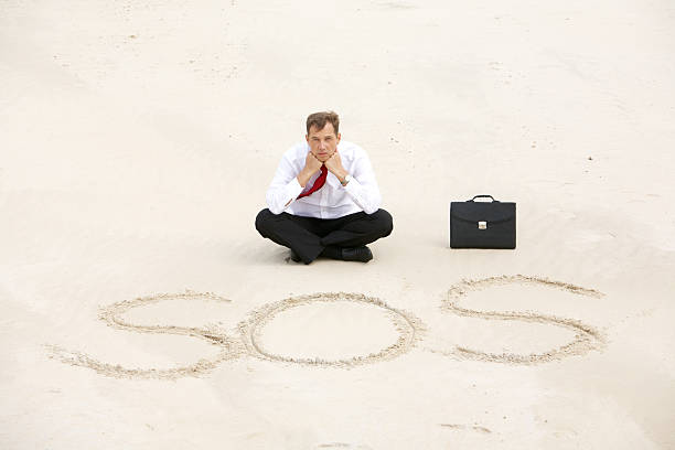 Help Conceptual image of a businessman calling out for help in desert desert island stock pictures, royalty-free photos & images