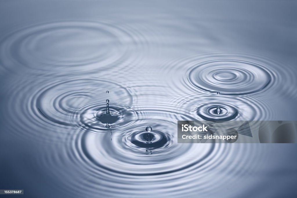 Las gotas de agua caída en azul de la piscina - Foto de stock de Agua libre de derechos