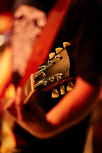 istock young man playing acoustic guitar in concert 155378726