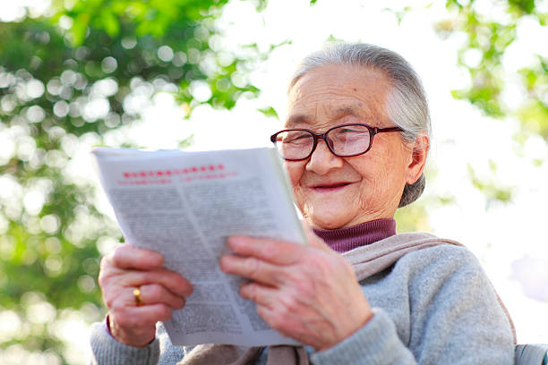 istock grandmother reading book in the garden 155378971