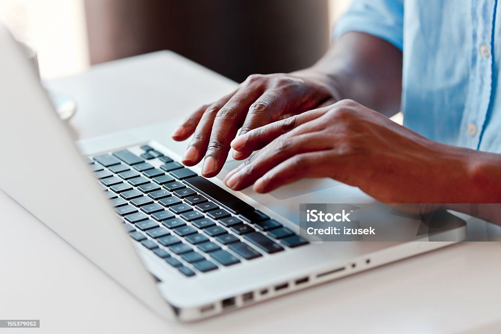 Using laptop Close-up on male hands typing on laptop keyboard. Typing Stock Photo