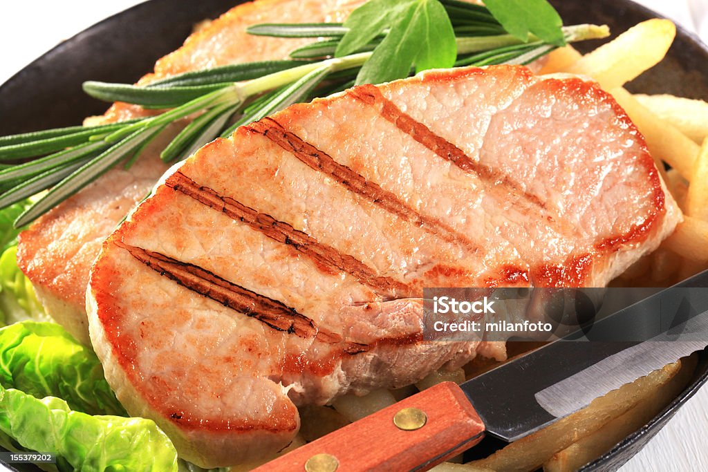 Cutlets con papas fritas en una cazuela - Foto de stock de Carne de cerdo libre de derechos