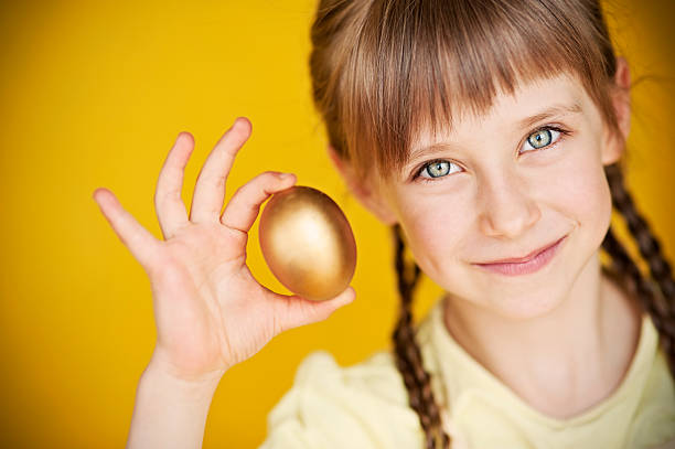 istock Little girl holding golden egg 155379225