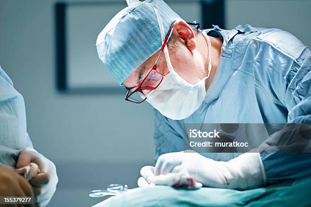 Surgeon Performing Surgery Stock Photo - Download Image Now - Adults Only, Blue, Color Image