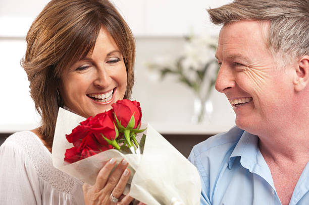 istock Man giving his happy wife red roses 155379308