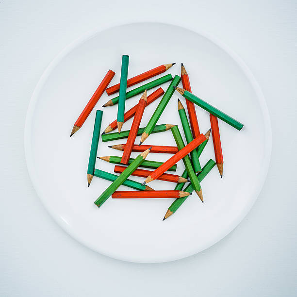 A row of pencils with green, brown and white stripes. The pencils are lined up next to each other. Pencils isolated on white background.