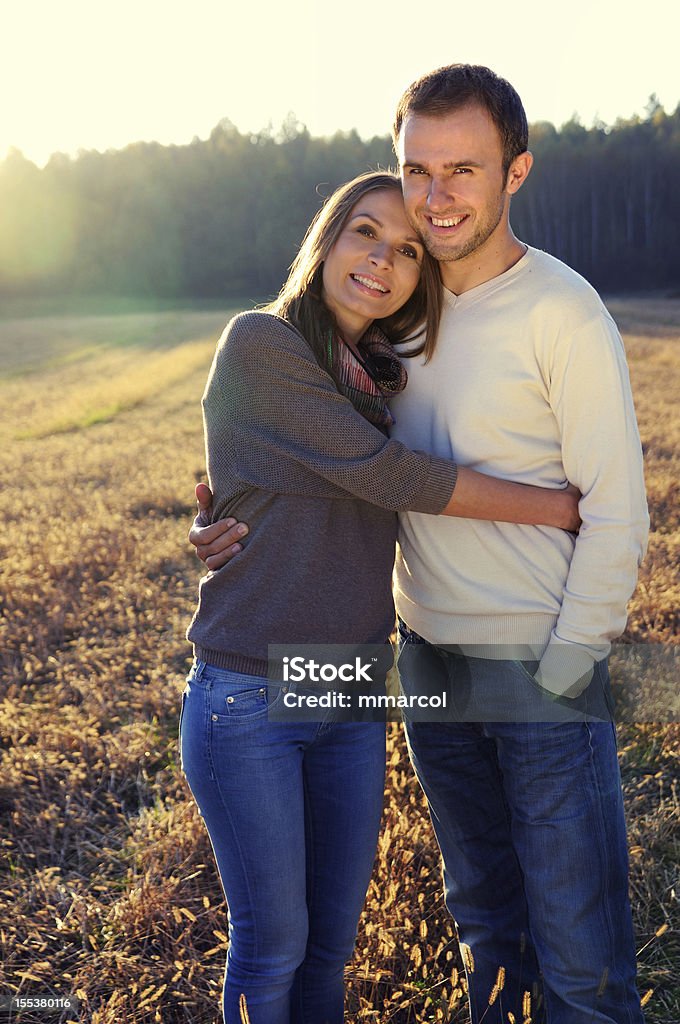 Young hugging couple in fall Young hugging couple in fall forest surroundings Adults Only Stock Photo