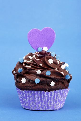 Cupcake with a heart shape, isolated on blue background