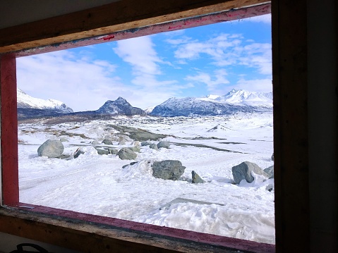 A view of Alaskan glaciers through a cabin window.
