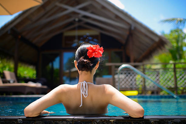 вид сзади на женщина в бикини, наслаждаясь бассейн - poolside enjoyment sensuality blue стоковые фото и изображения