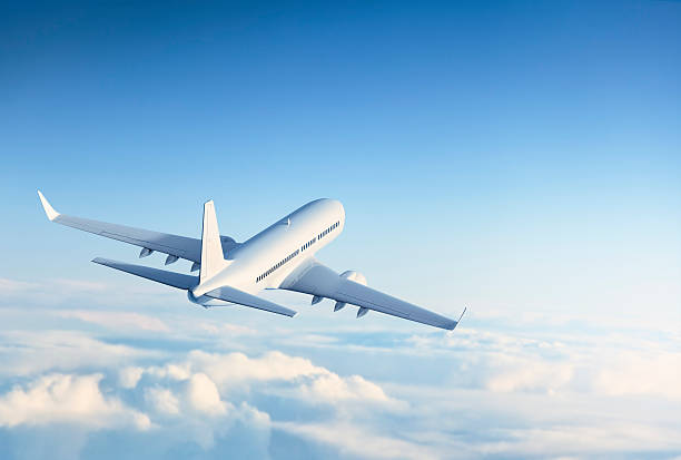 Commercial jet flying over clouds stock photo