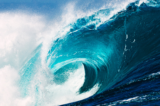 A huge blue wave explodes on the reef.