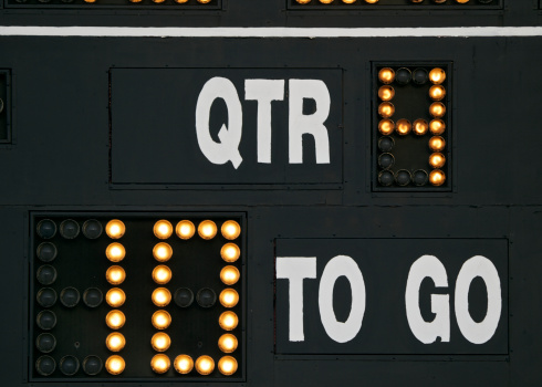 A partial view of a Scoreboard on an American football field. 4th Quarter and 10 yards to go are shown. This is on a High School football field in Oregon.