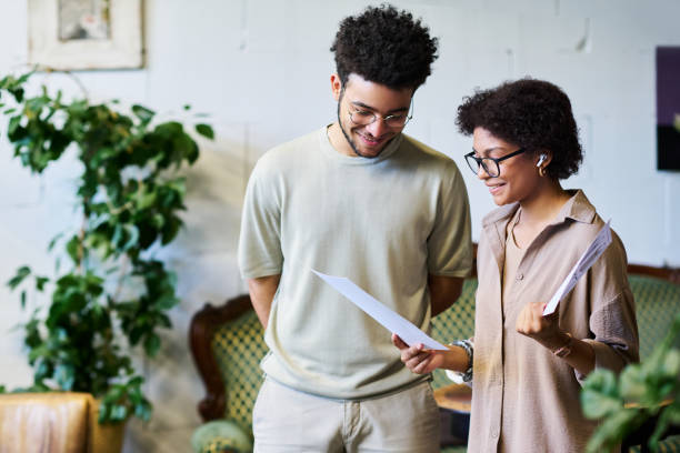 istock Two happy young brokers in casualwear discussing financial documents 1553817020