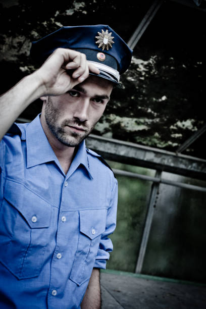 istock policeman in blue uniform greeting with his hand at cap 155381977
