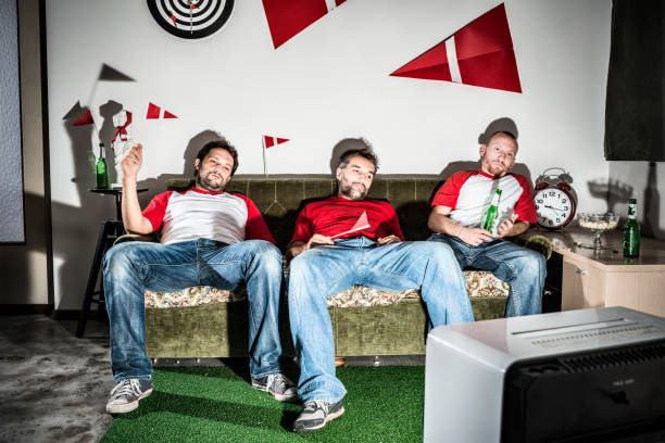 tres hombres adultos jóvenes amigos viendo el fútbol en televisión: la derrota - television boredom men sofa fotografías e imágenes de stock