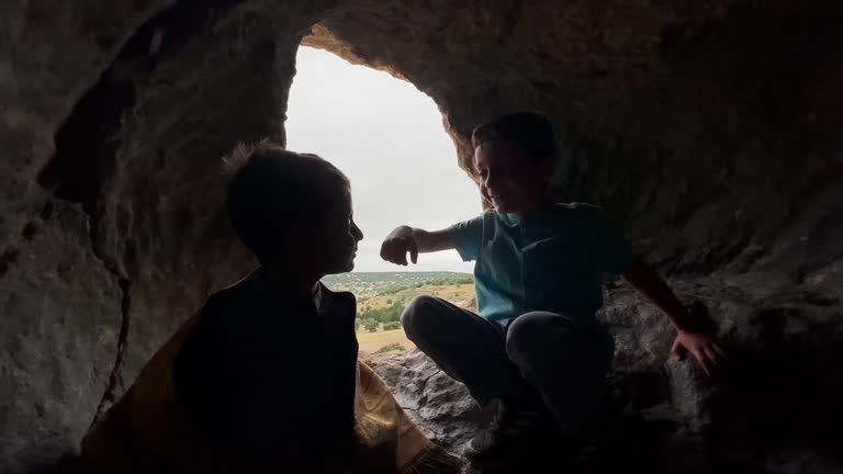 Brothers having fun with sticks in cave in Phrygian Valley