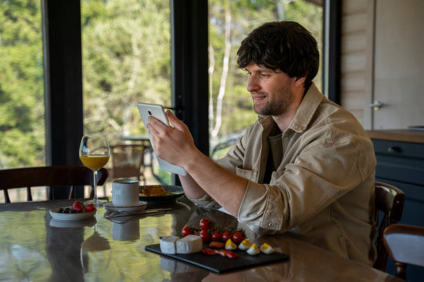 istock A single man has breakfast in the kitchen, working from home.A man uses a tablet during breakfast in the kitchen. 1553830028