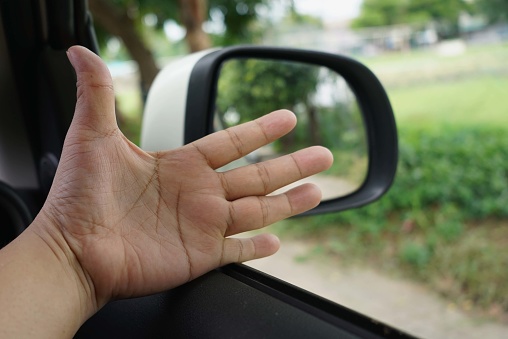Abstract a hand on the side of the car with blur background, focus on hand.