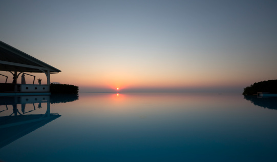 The elegance of an infinity pool at sunset time