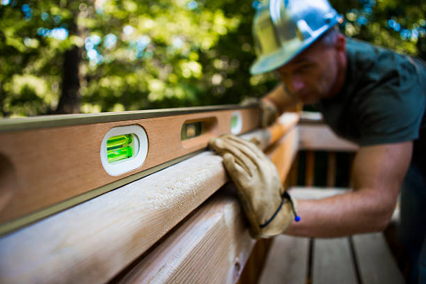 Male Carpenter Working With Spirit Level. Male carpenter with spirit level working on deck. Horizontal shot. spirit level stock pictures, royalty-free photos & images