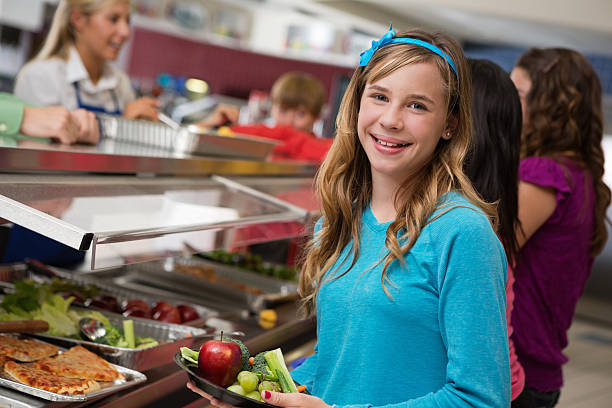 istock Middle school girl with students in cafeteria lunch line 155383292