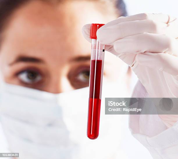 Grave Femmina Scienziato Esaminando Flacone Di Liquido Rosso Sangue Eventualmente - Fotografie stock e altre immagini di Adulto