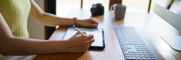 istock Graphic designer working on digital tablet and computer. Designer Asian Woman artist drawing on graphic tablet  Artist Creative Designer sketch graphic drawing creative. 1553834507