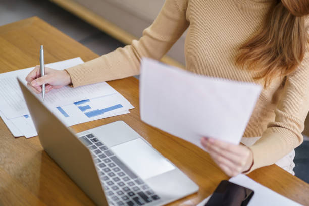 istock Happy beautiful Asian woman using computer laptop for work online at living room. 1553835645