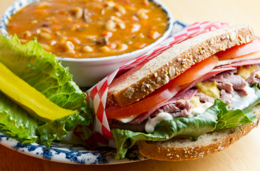 Delicious deli-style roast beef sandwich with a bowl of soup.