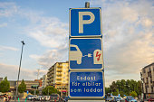 Close up view of parking sign for charging electric vehicles in parking lot near mall. Sweden.