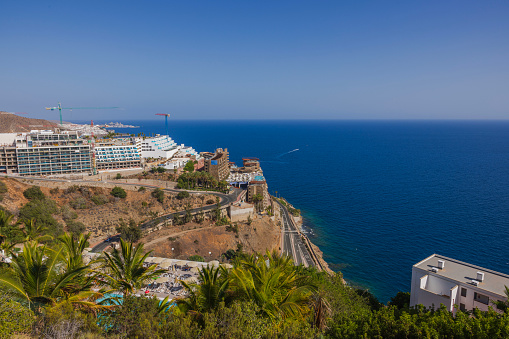 Beautiful view of mountainous coast of Atlantic Ocean with highway and hotels on mountain. Gran Canaria. Spain.