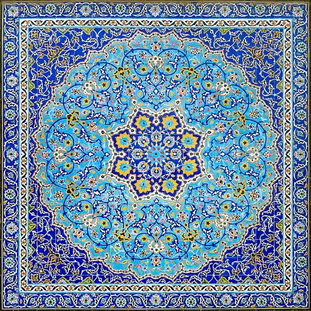 Geometrical islamic and  arabic style full frame tile tableau. A mosaic of mostly blue tiles with a square and circle pattern. A symmetrical wall decoration in the Golestan Palace in Tehran, Iran. The center looks like a flower.