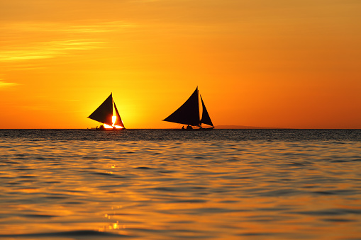 Two sailboats and beautiful sunset at Boracay island, Philippines