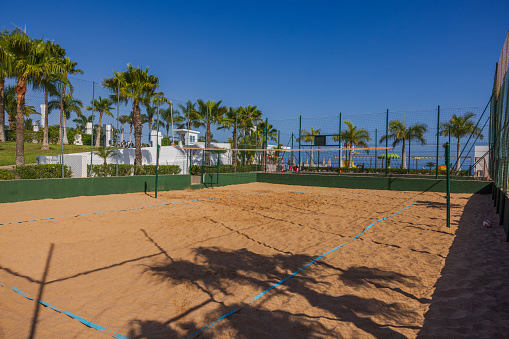 Gran Canaria. Spain. 07/16/2023. Beautiful view of hotel with fenced sandy volleyball court.