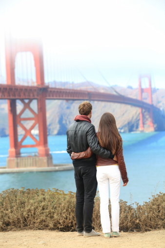 San Francisco Golden Gate Bridge. Young traveling couple enjoying view of the travel icon landmark and San Francisco Bay. Click on the banners for more: