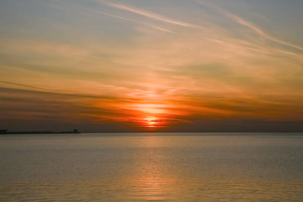istock sun setting in the clouds over the sea 1553838922