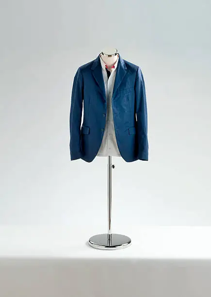 tailor made blue jacket and white shirt on mannequin on white background