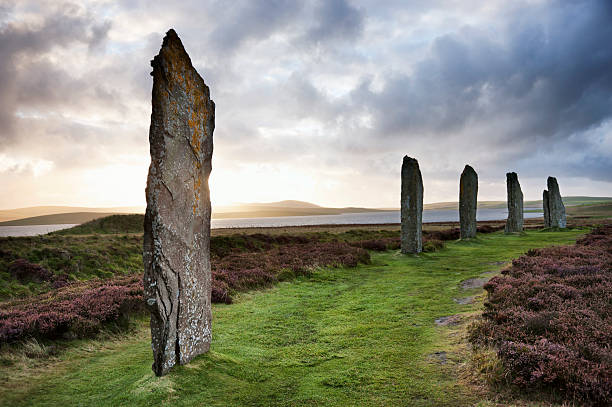 Ring Of Brodgar, Orkney The ancient standing stones of the Ring of Brodgar in the Orkney Islands off the north coast of Scotland, in the evening just at sunset. This monument in the heart of the Neolithic Orkney World Heritage Site is believed to have been built between 4000 and 4500 years ago. Originally built with sixty stones in a circle over 100 metres (over 100 yards) across, fewer than half of the stones still stand. The tallest of the stones is a little over 4.5 metres (15 feet) tall. orkney islands stock pictures, royalty-free photos & images