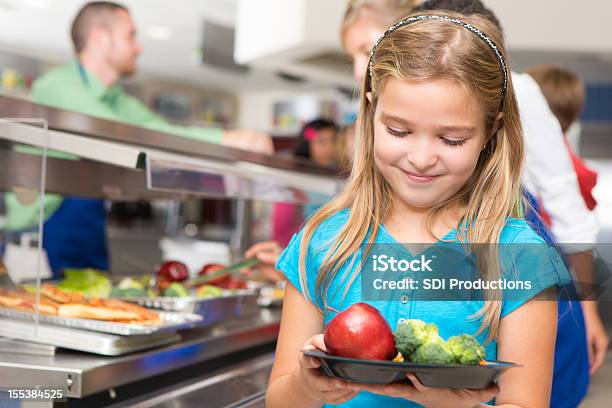 Счастливый Маленькая Девочка Делая Здоровый Выбор В Школьной Столовой — стоковые фотографии и другие картинки Школьный обед