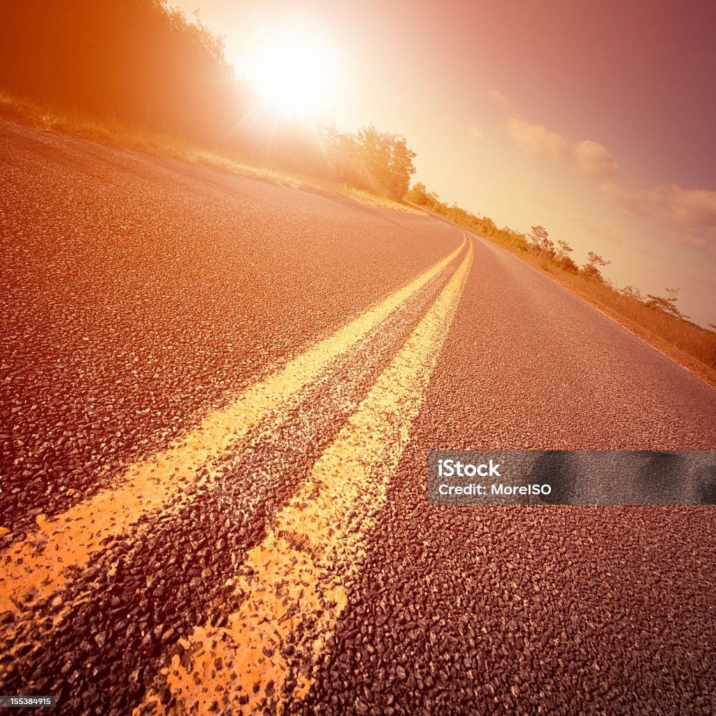 Strada verso l'orizzonte al tramonto - Foto stock royalty-free di Strada del deserto