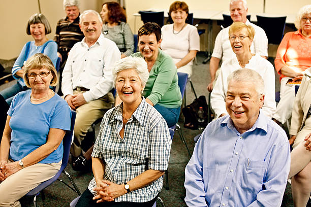 grupo grande de ancianos sonriente - senior adult group therapy social gathering community center fotografías e imágenes de stock