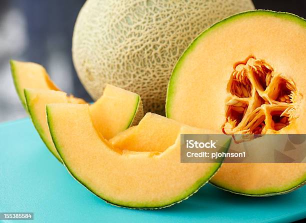 A Close Up Of A Sliced Cantaloupe On A Blue Table Stock Photo - Download Image Now - Cantaloupe, Melon, Cross Section