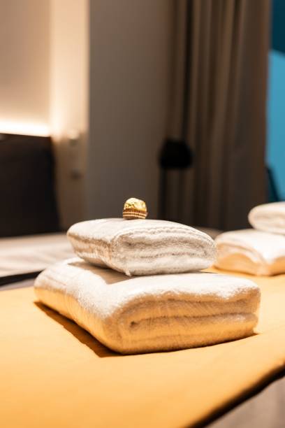 istock Cozy hotel bedroom with clean towels on the bed. 1553856066