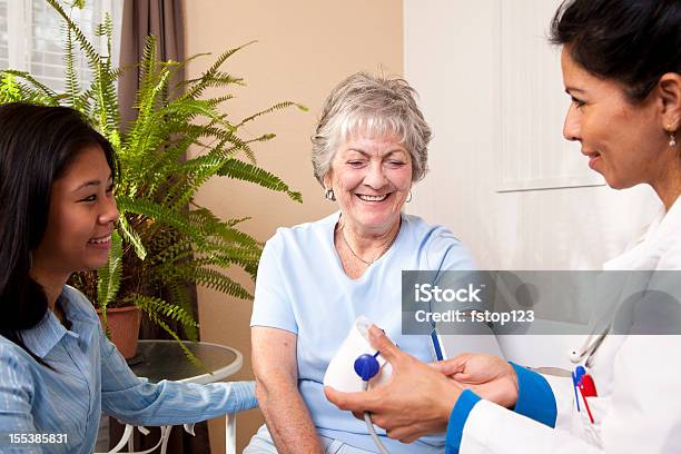 Foto de Sênior Mulher Recebendo Pressão Arterial Checkin No Consultório Médico e mais fotos de stock de 20 Anos